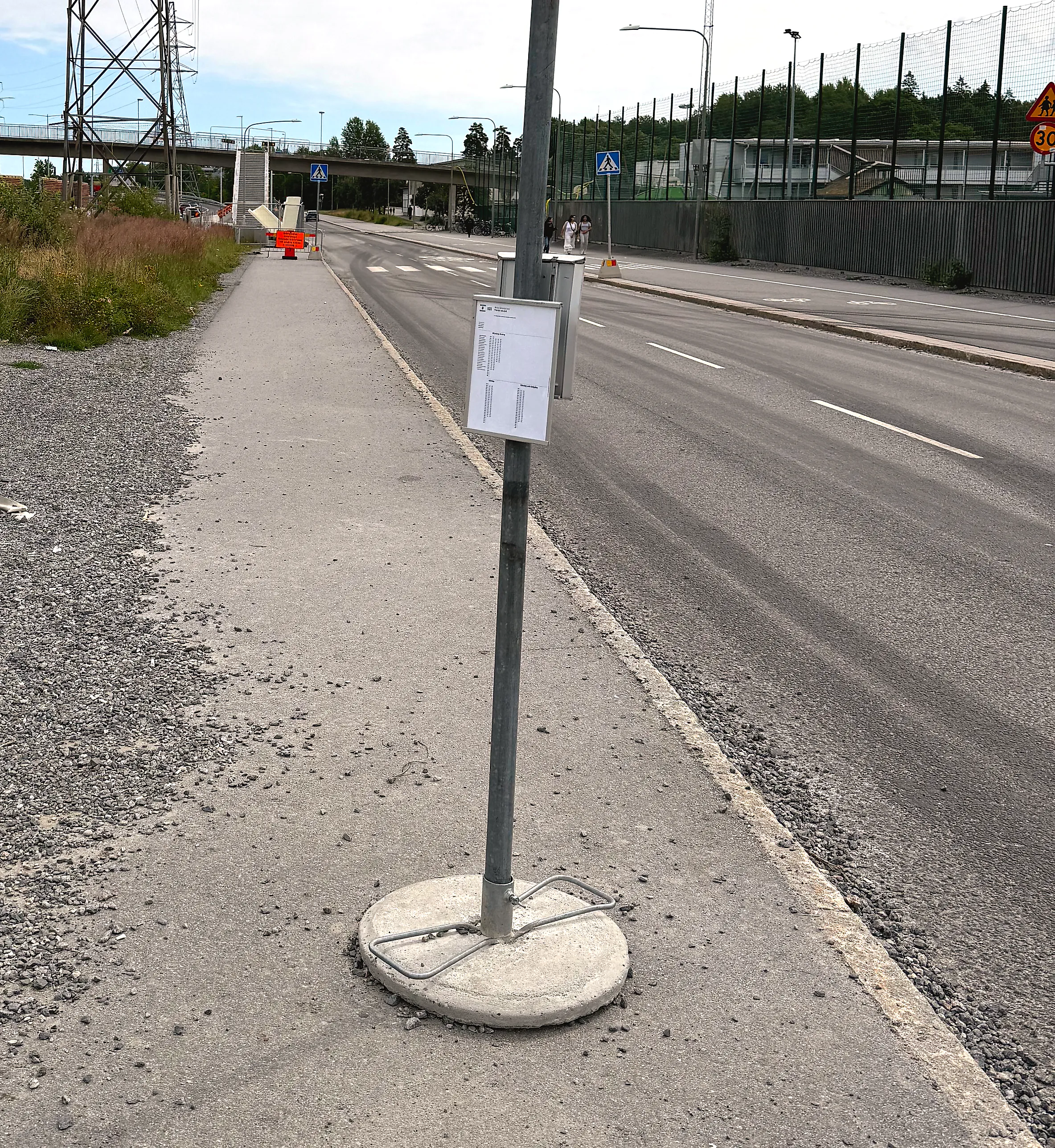 Tecknad grå buss vid en trottoar med en blank, textlös reklamyta på sidan i grå dagsljus.