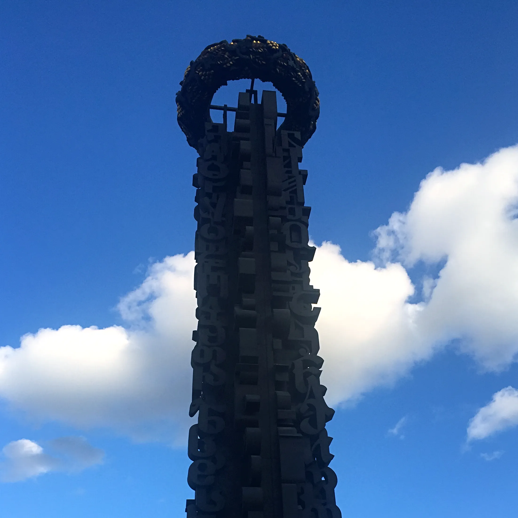 Högt monument i form av en prydd obelisk.